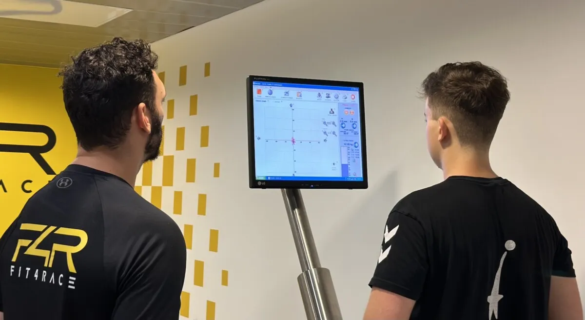 Fit4Race szakember és fiatal sportoló együtt nézik a mérési eredményeket a monitoron